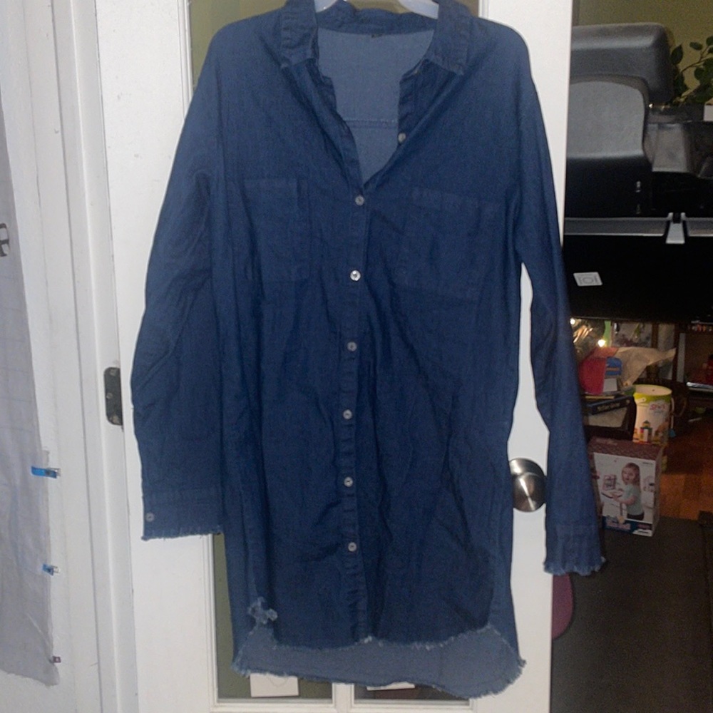 Denim button down shirt dress with frayed edges at the sleeves and bottom hem.